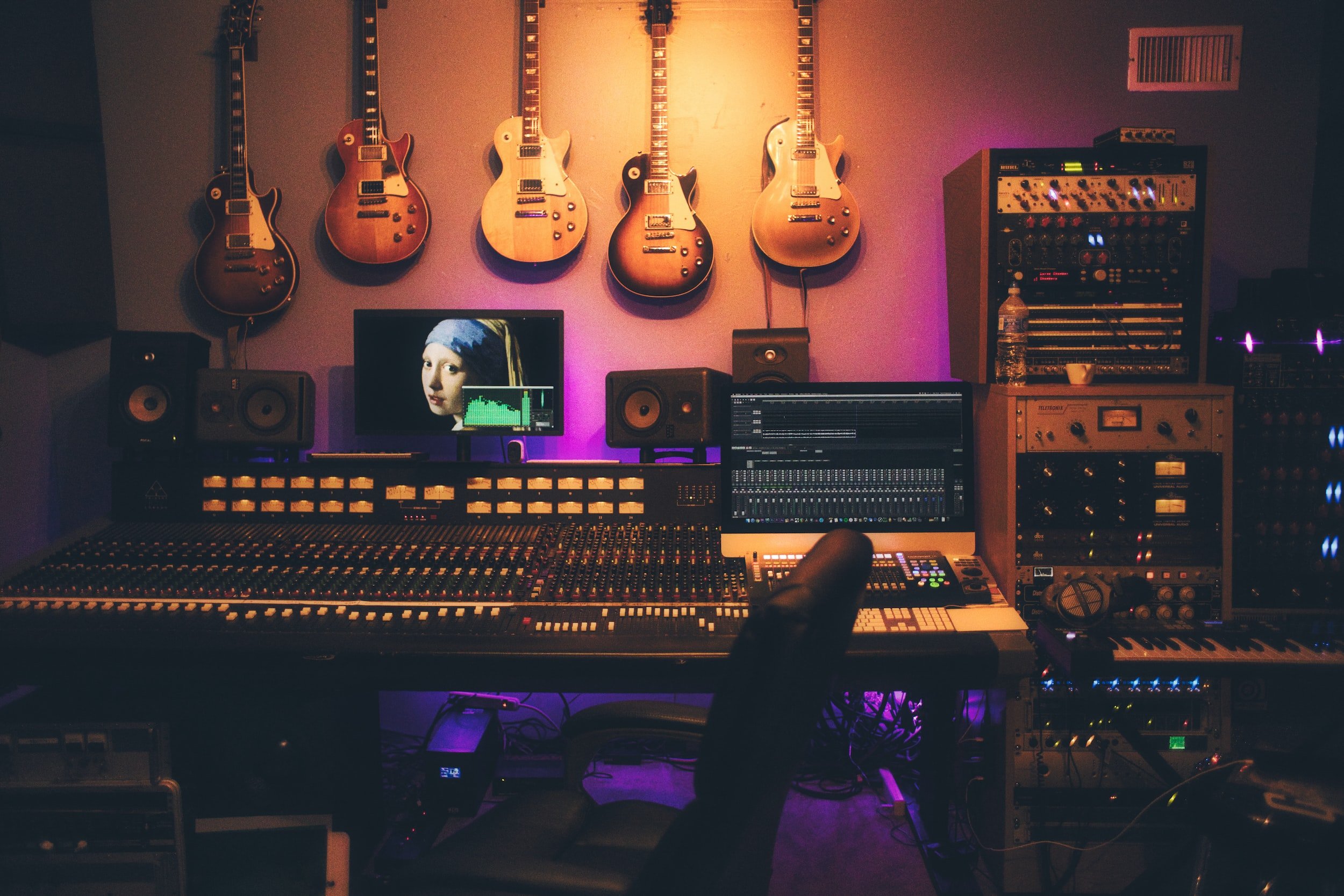 Sound equipment with guitars on the wall.
